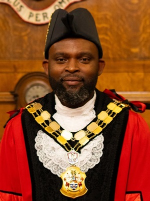 Mayor of Islington, Cllr Jason Jackson in red robes and chain smiling at the camera